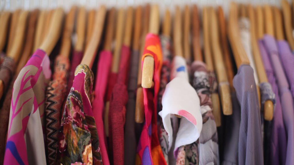 A photo of clothing on a rack in a boutique shop.